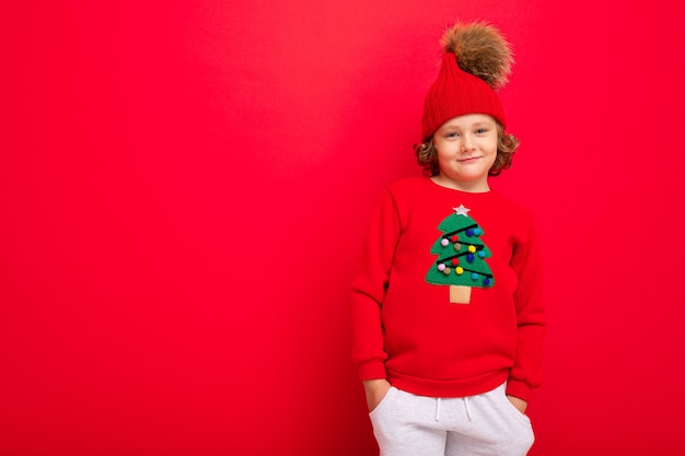 Leuke jongen met een kersttrui en een hoed