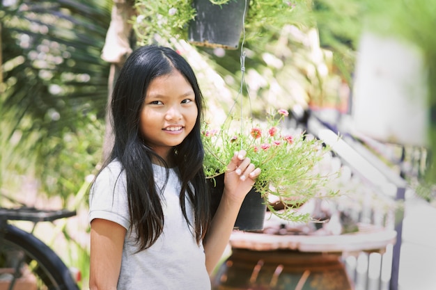 Leuke kinderen die glimlach bevinden zich bij park en bloemachtergrond