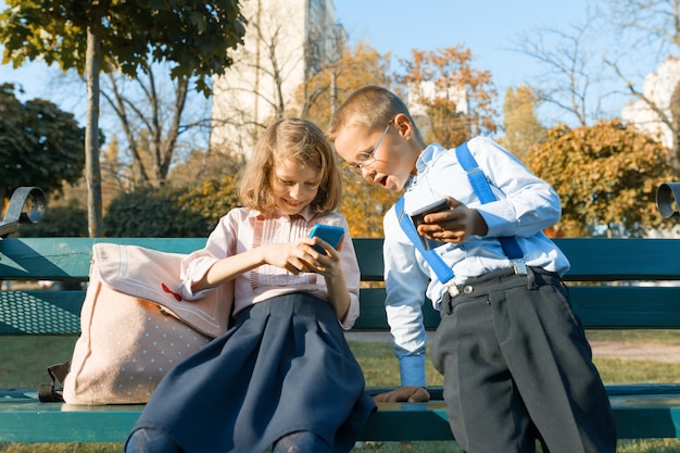 Leuke kinderen jongen en meisje zijn op zoek naar smartphones