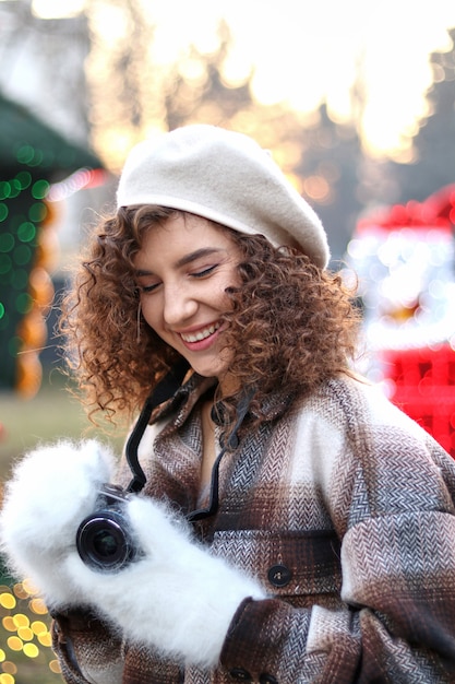 Leuke krullende haar jonge vrouw die foto's met de camera nemen