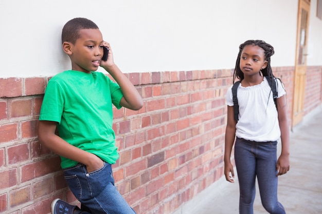 Leuke leerling die op zijn smartphone in gang spreekt