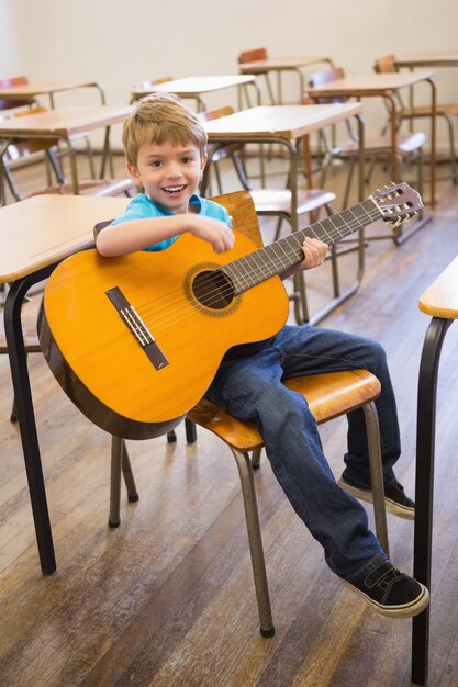 Leuke leerling gitaarspelen in de klas