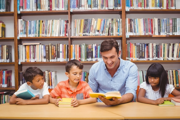 Leuke leerlingen en leraar die in bibliotheek lezen