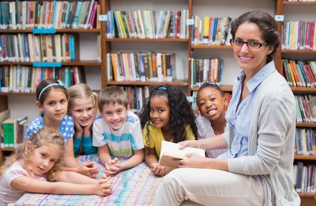 Leuke leerlingen en leraar die in bibliotheek lezen