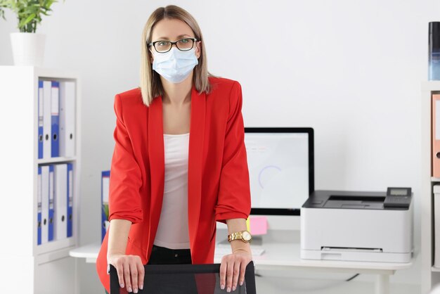 Leuke manager met medisch masker poseren op kantoor