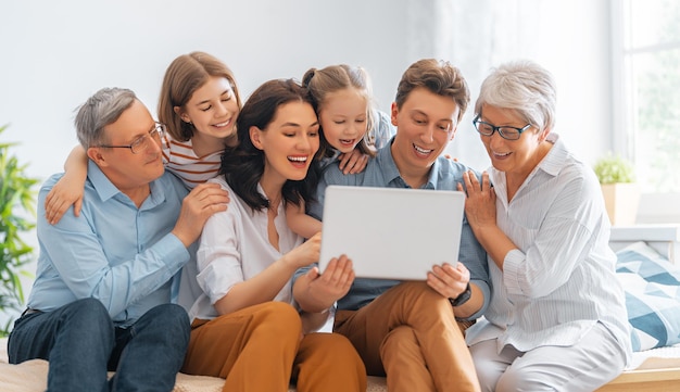 Foto leuke meiden, hun moeder, vader, opa en oma genieten samen thuis. familie tijd.