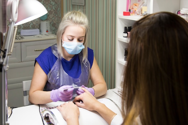 Leuke meisjesmeester die een manicure doet.