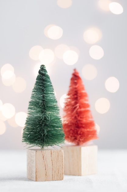 Leuke miniatuur kerstbomen op een witte tafel met bokeh lichten