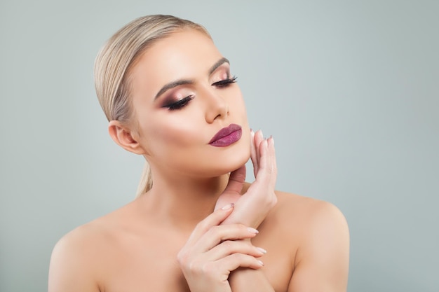 Leuke modelvrouw met gezonde huid op blauwe achtergrond. schoonheid, gezichtsbehandeling en cosmetologieconcept