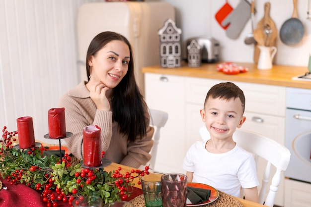 Leuke moeder en zoon spelen in de keuken gelukkig tijd doorbrengen op kerstavond en oudejaarsavond