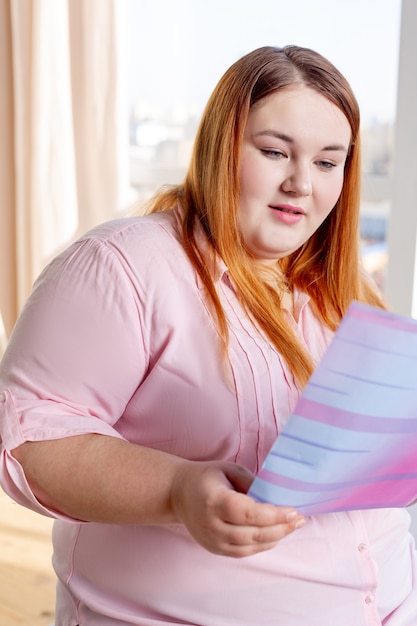 Leuke mollige jonge die een tijdschrift leest over gezondheid terwijl je gezond wilt zijn