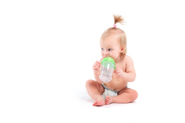 Leuke mooie baby in de witte fles van de luiergreep