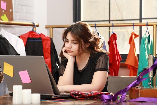 Leuke mooie dame die aan het bureau zit en naar haar pc kijkt