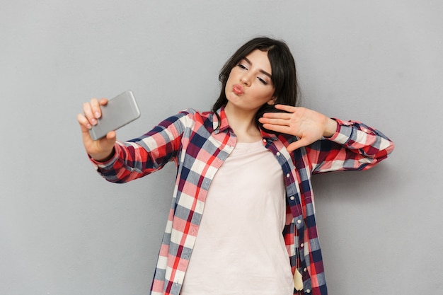 Leuke mooie jonge dame maken selfie via de mobiele telefoon.