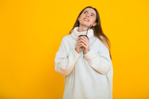 Leuke mooie jonge vrouw over gele achtergrond