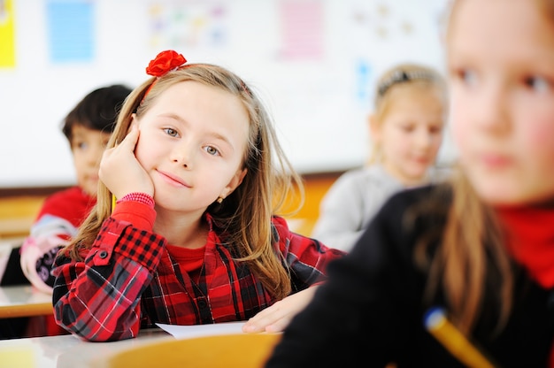 Leuke mooie schoolkinderen in klaslokaal die onderwijactiviteiten hebben