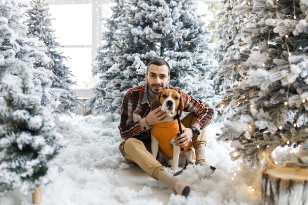 Leuke nieuwjaarsfoto van een man en zijn hond portret feestelijke foto's van een hond in nieuwjaarsversieringen