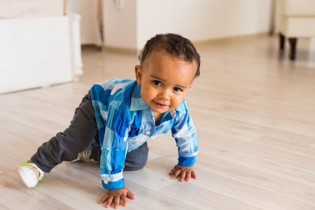 Leuke nieuwsgierige baby bestudeert dingen in de kamer.