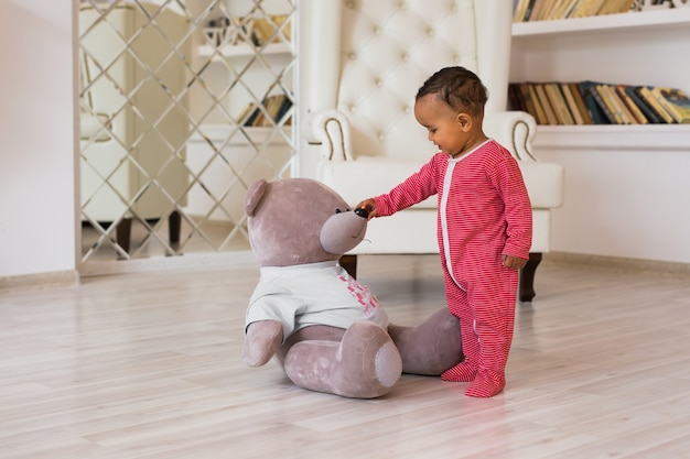 Leuke nieuwsgierige baby bestudeert dingen in de kamer.