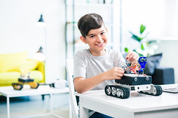 Leuke optimistische kleine jongen die robot bouwt terwijl hij zich voorbereidt op technische lessen
