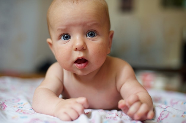 Leuke pasgeboren baby van 3 maanden die thuis in bed ligt