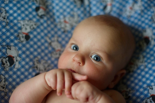 Foto leuke pasgeboren baby van 3 maanden die thuis in bed ligt