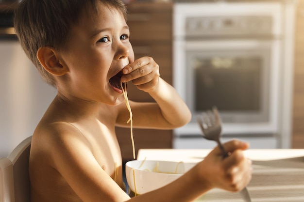 Leuke peuter die zijn favoriete spaghetti eet.