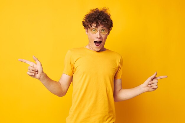 Leuke roodharige man gele t-shirt bril mode handgebaren geïsoleerde achtergrond ongewijzigd