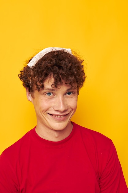 Leuke roodharige man met een rood t-shirt medisch masker op het gezicht poseren geïsoleerde achtergrond ongewijzigd