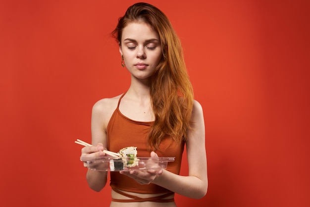 Leuke roodharige vrouw eetstokjes broodjes en zeevruchten snack