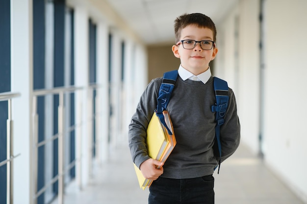 Leuke schooljongen met boeken en een rugzak