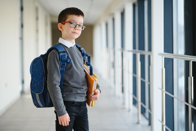 Leuke schooljongen met boeken en een rugzak