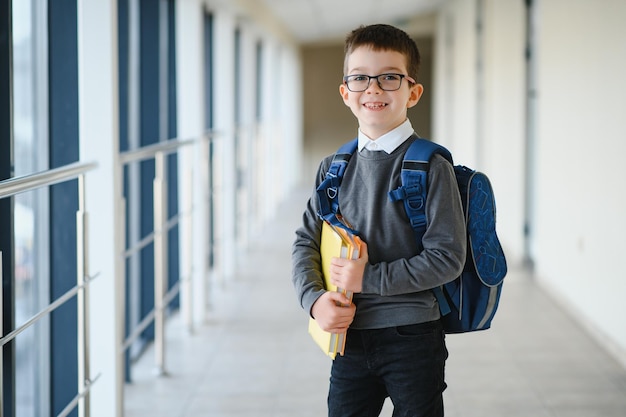 Leuke schooljongen met boeken en een rugzak