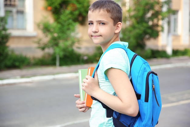 Leuke schooljongen met boeken op straat