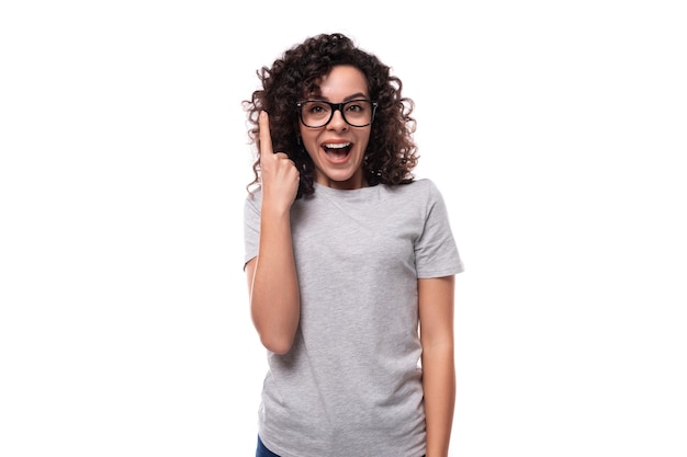 Leuke slanke jonge blanke vrouw met zwart krullend haar gekleed in een grijs t-shirt met printruimte