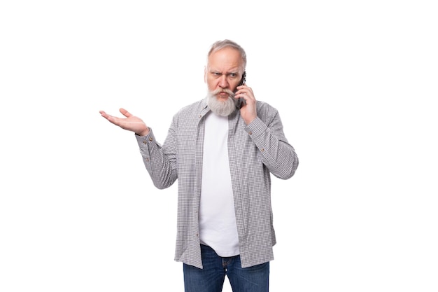 Leuke slimme grootvader met een witte baard en snor gekleed in een gestreepte shirt over een t-shirt