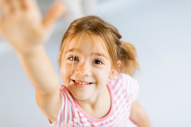 Leuke smiley meisje stijgende hand naar voren