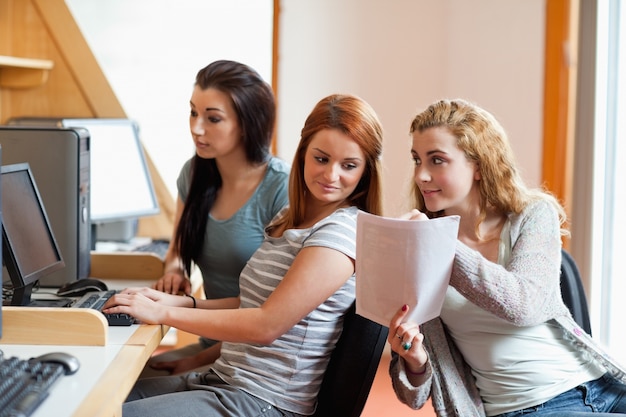 Foto leuke student die haar nota's toont aan haar klasgenoot