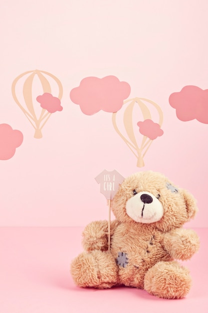 Leuke teddybeer over de roze pastelkleurachtergrond met wolken en impulsen