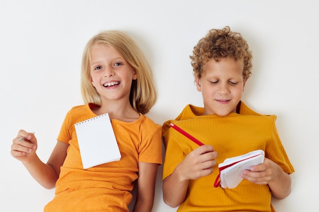 Leuke voorschoolse kinderen die leuke spelletjes tekenen met een notitieblok geïsoleerde achtergrond ongewijzigd