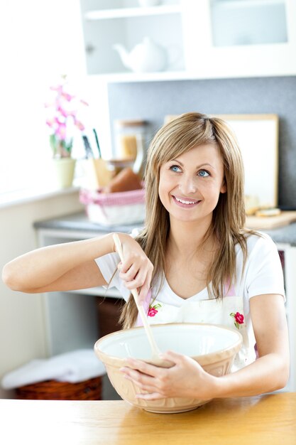 Leuke vrouw die een cake in de keuken voorbereidt