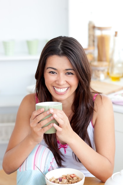 Leuke vrouw die een kop houdt een koffie in de keuken