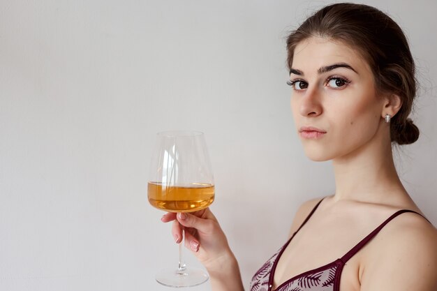 Leuke vrouw die van glas witte wijn geniet