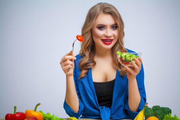 Leuke vrouw eet groente salade met veel vitamines