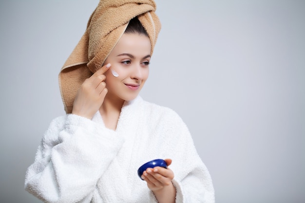 Leuke vrouw in badkamer doen cosmetische procedure voor gezichtshuid zorg