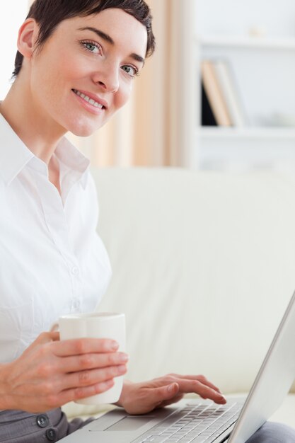 Leuke vrouw met een kop en laptop