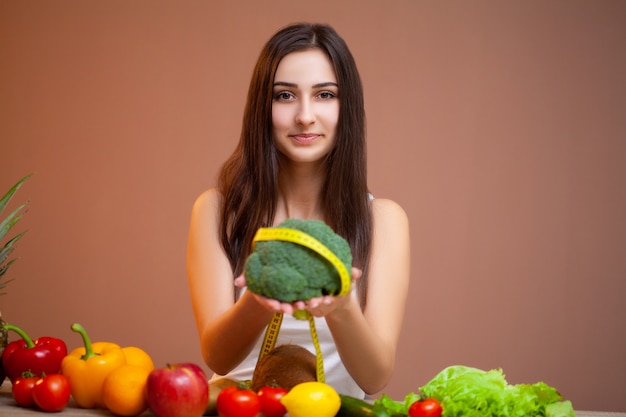 Leuke vrouw met verse groenten en fruit leidt een gezonde levensstijl