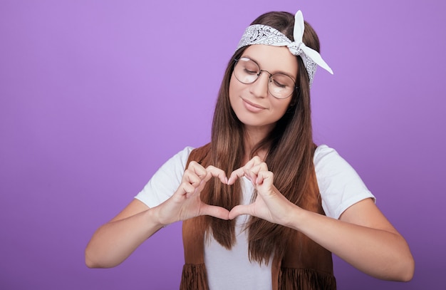 Leuke vrouw toont handen een hart.