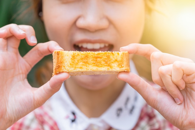 Leuke vrouwen die botertoost houden die in de ochtendclose-up eten