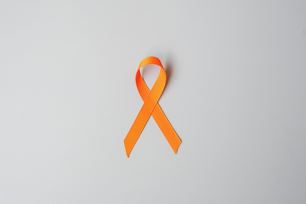 白血病、腎臓がんの日、世界の多発性硬化症、crps、自傷行為防止月間、生きている人々と病気をサポートするためのオレンジリボン。ヘルスケアと世界対がんデーのコンセプト